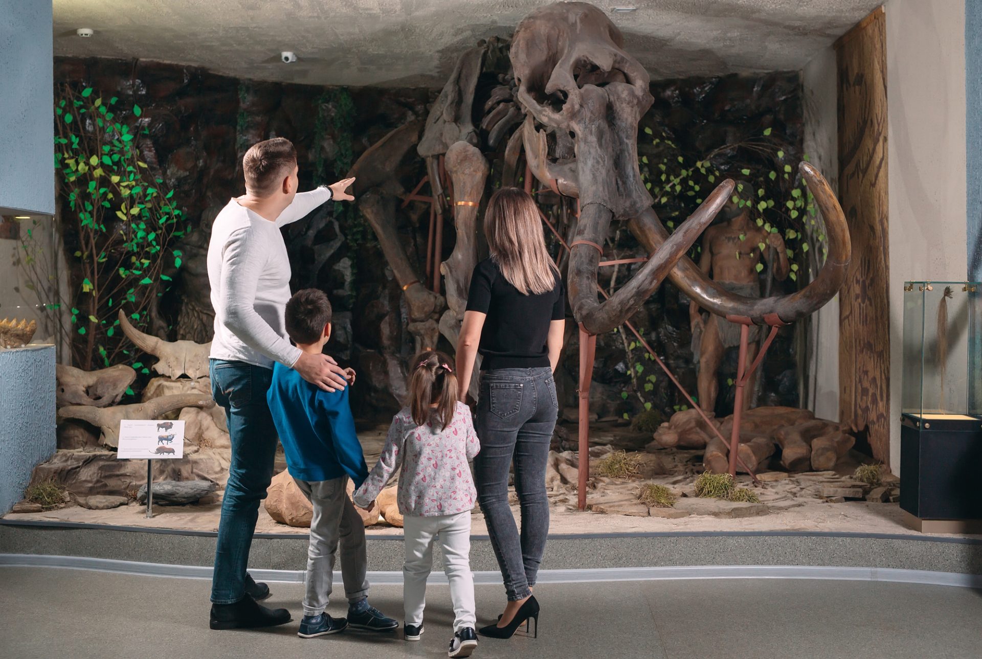 Family outing to the museum. In the prehistoric era, a family poses with an elderly elephant.